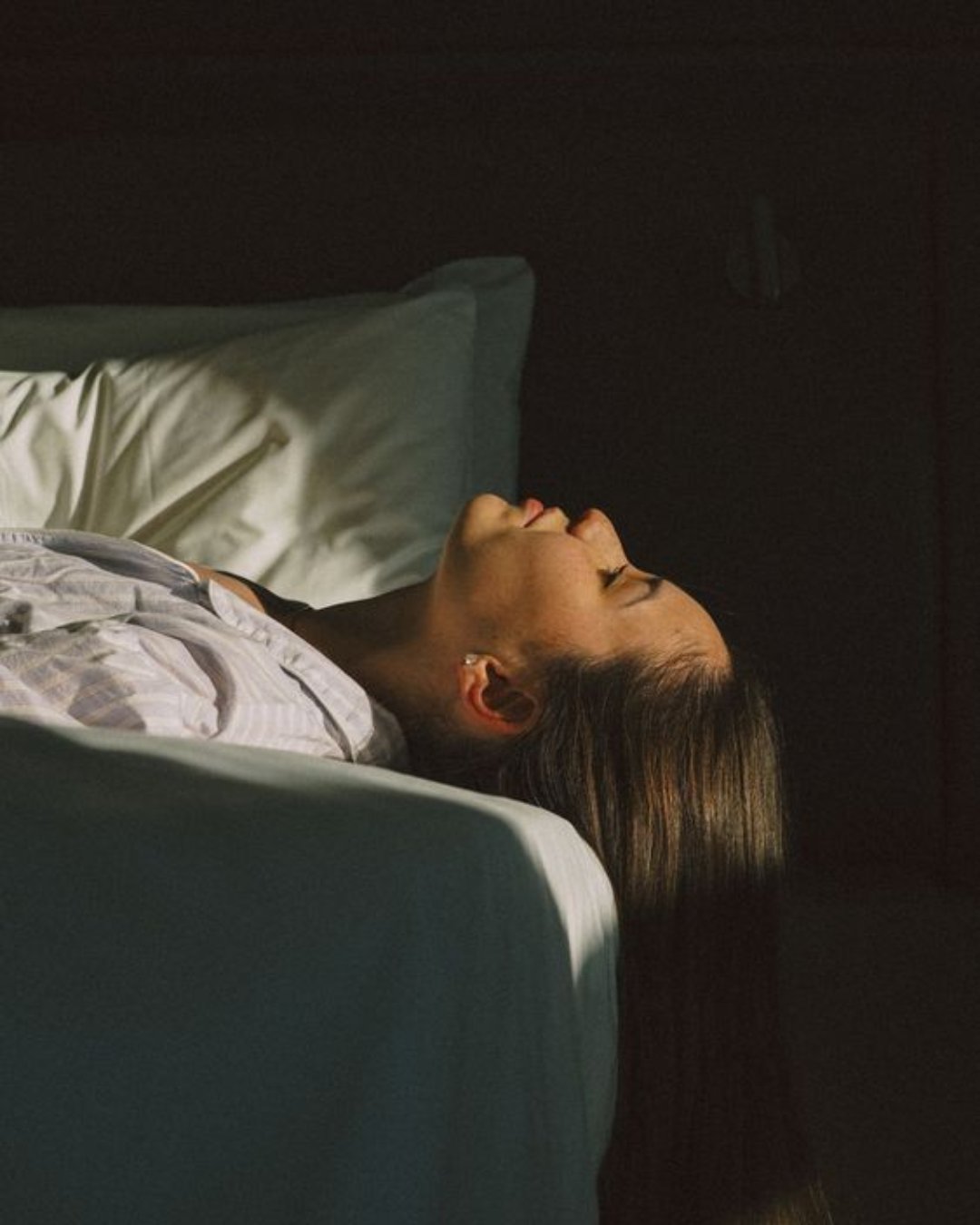 Woman resting, bathed in soft light, receiving a distance Reiki session
